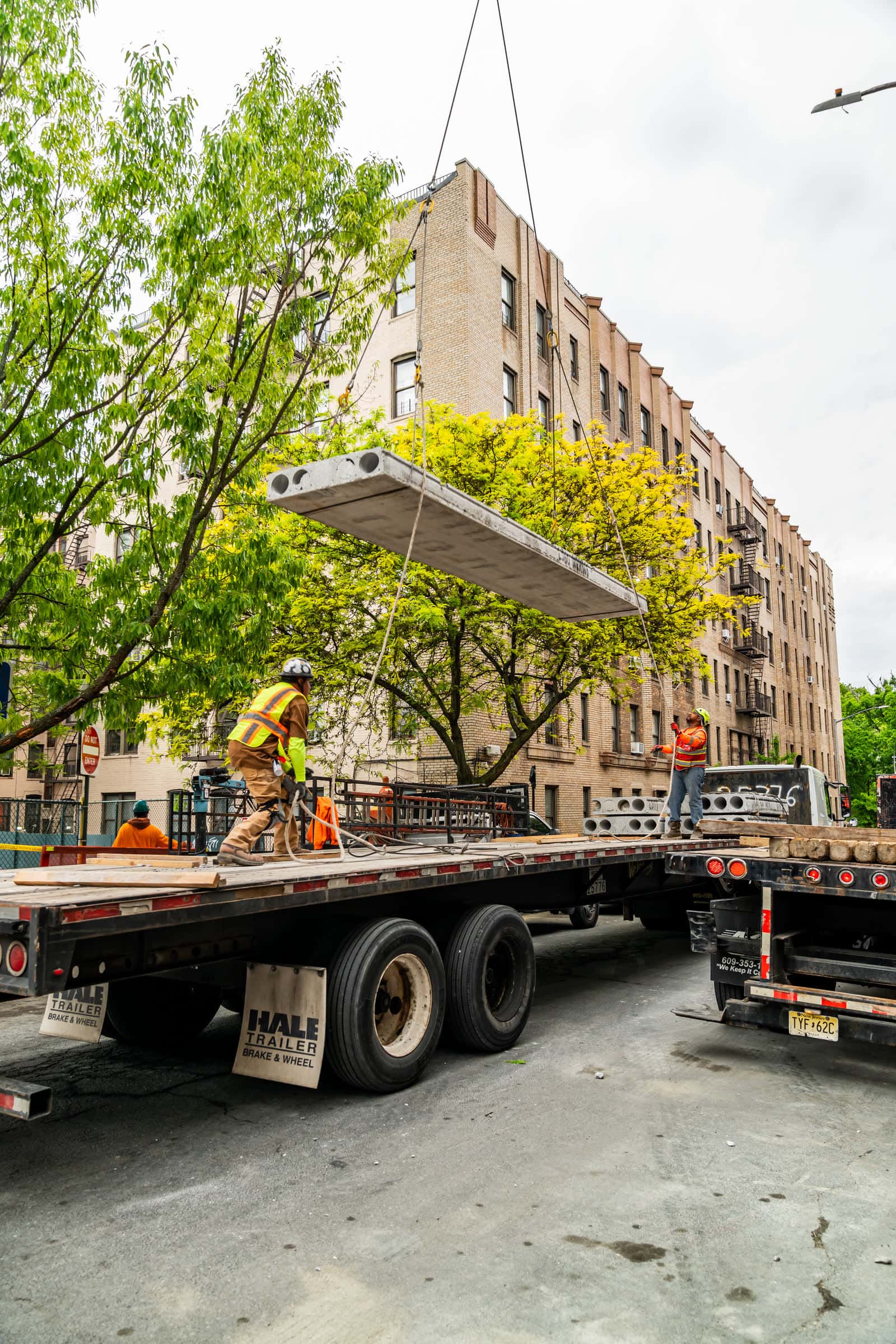 Hollow-core plank suspended over a street between trees