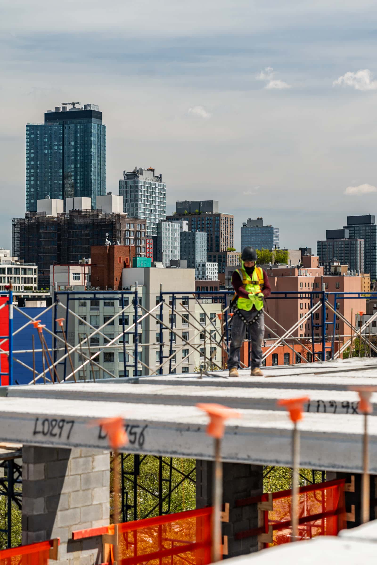 Worker standing at a plank edge with towers behind